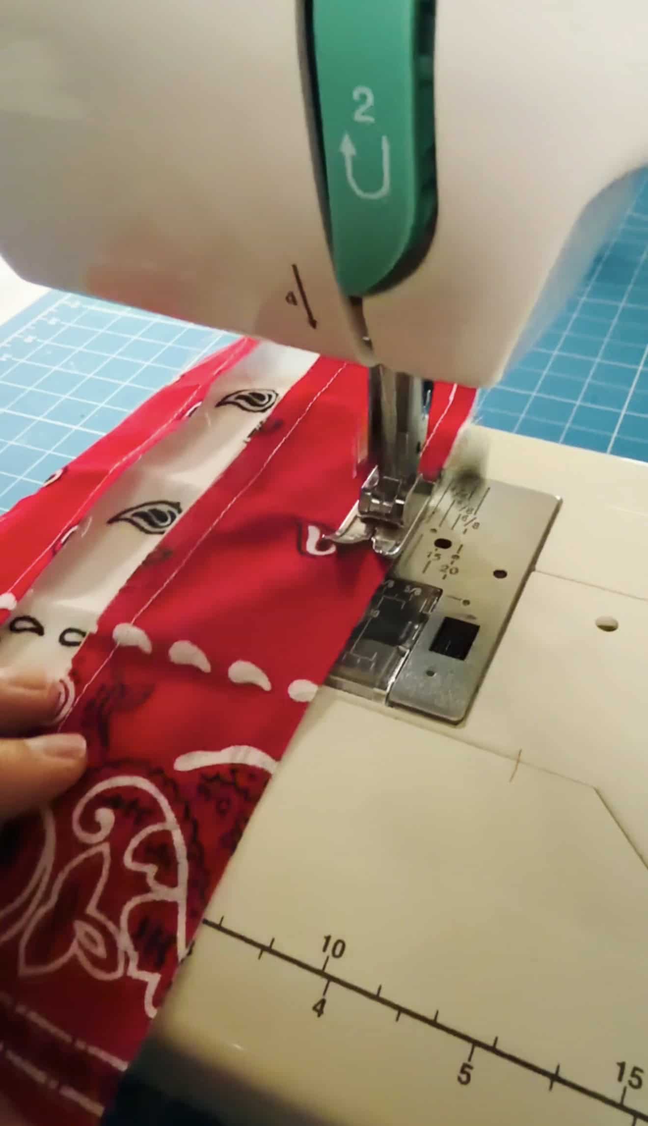 Sewing machine sewing rows or red and white bandans together.