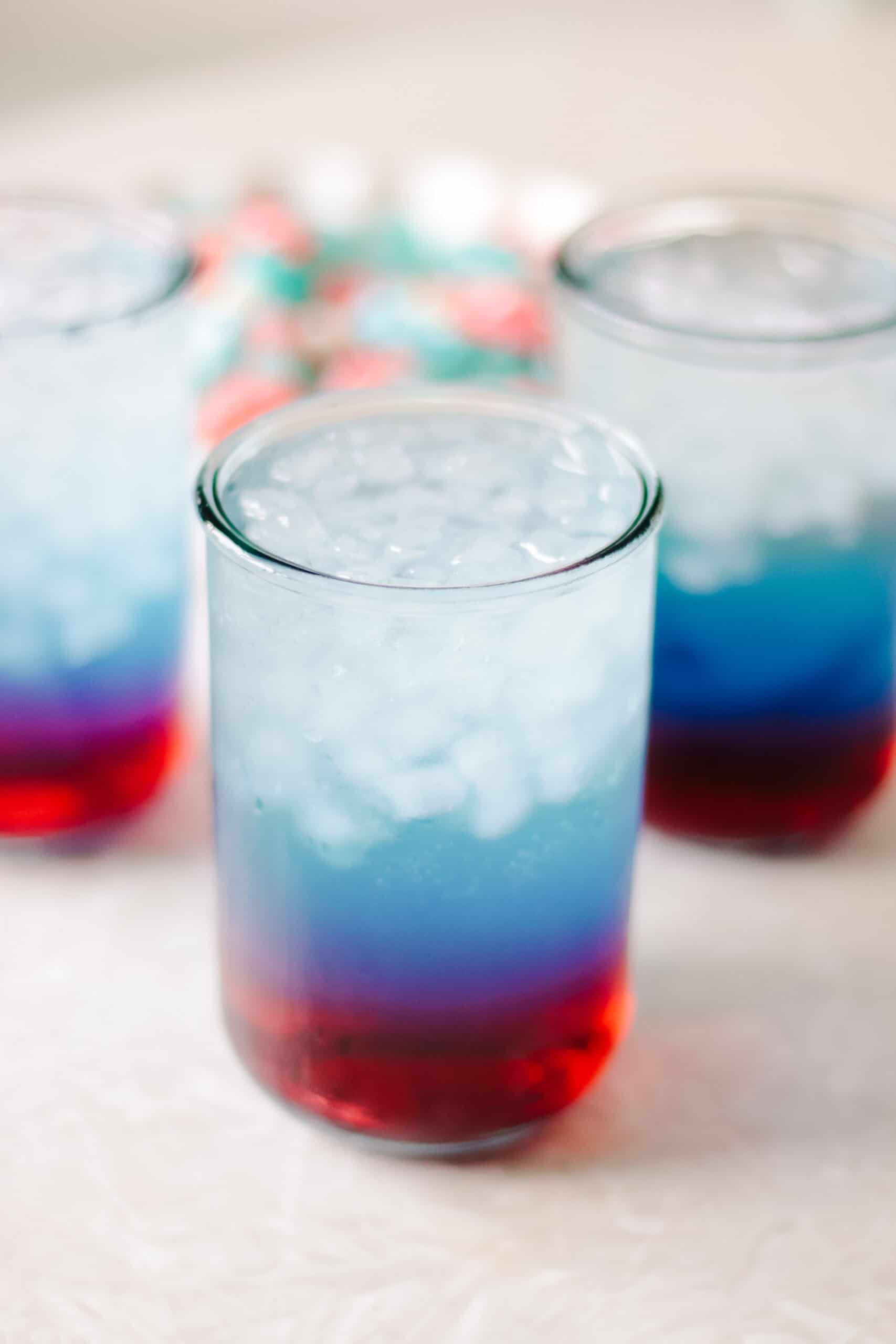Red, white and blue punch in glass with ice.