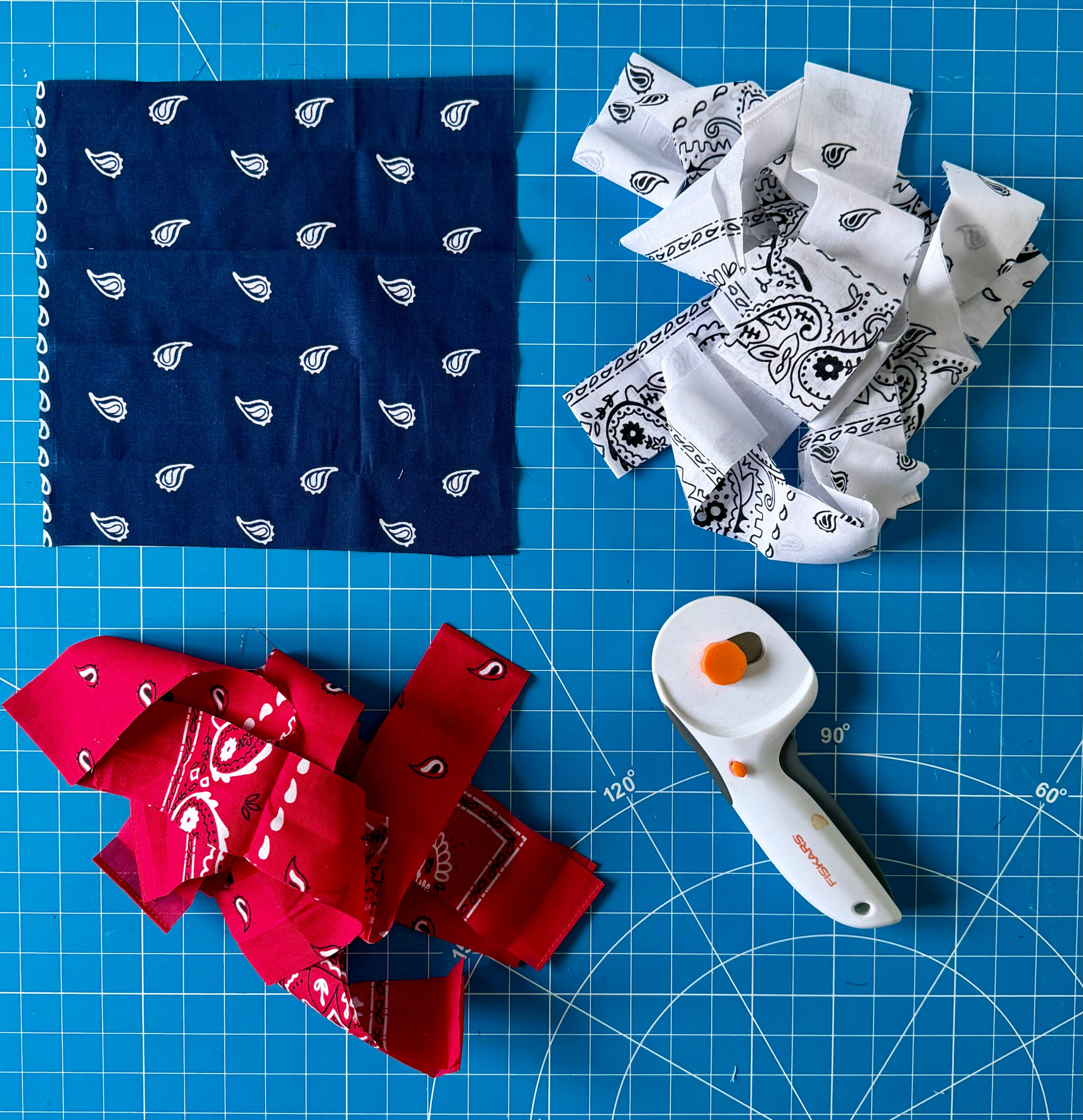 Square of blue fabric and strips of red and white fabric.
