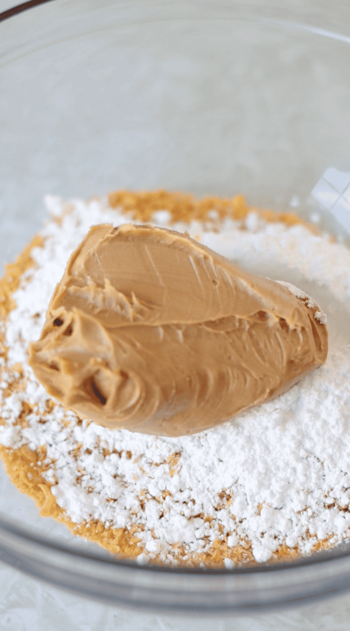 Bowl with peanut butter, corn flakes and powdered sugar.
