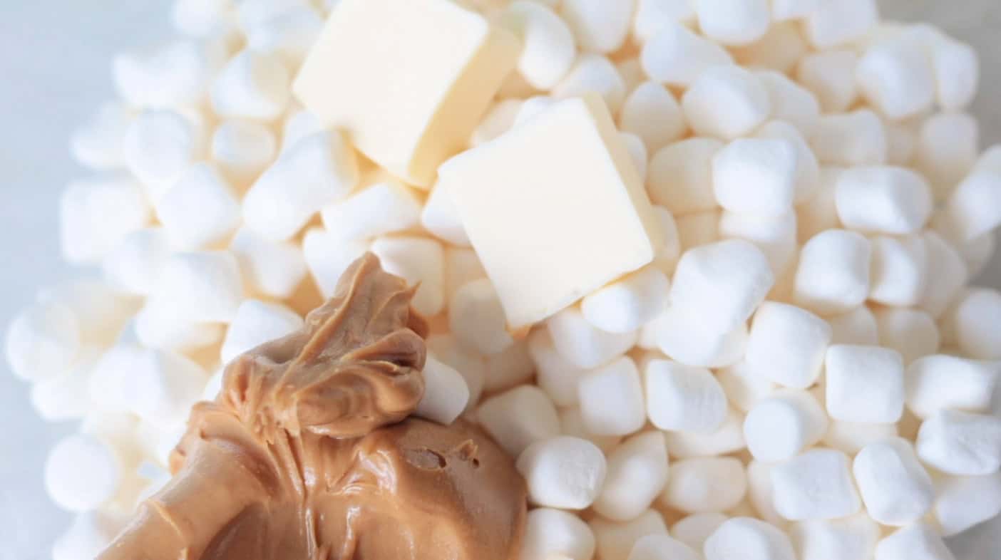 Marshmallows, slices of butter and peanut butter in a bowl.