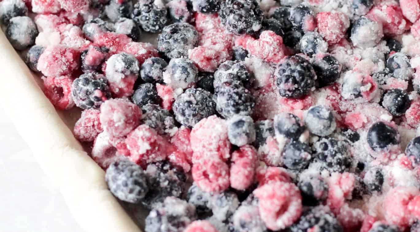 Mixed berry pie filling in pie crust.