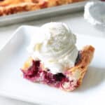 White plate with a slice of mixed berry pie.