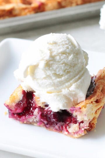 White plate with a slice of mixed berry pie.