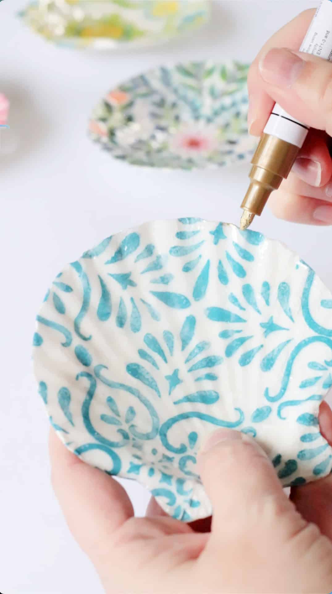 Gold pen outlining decoupage shell.
