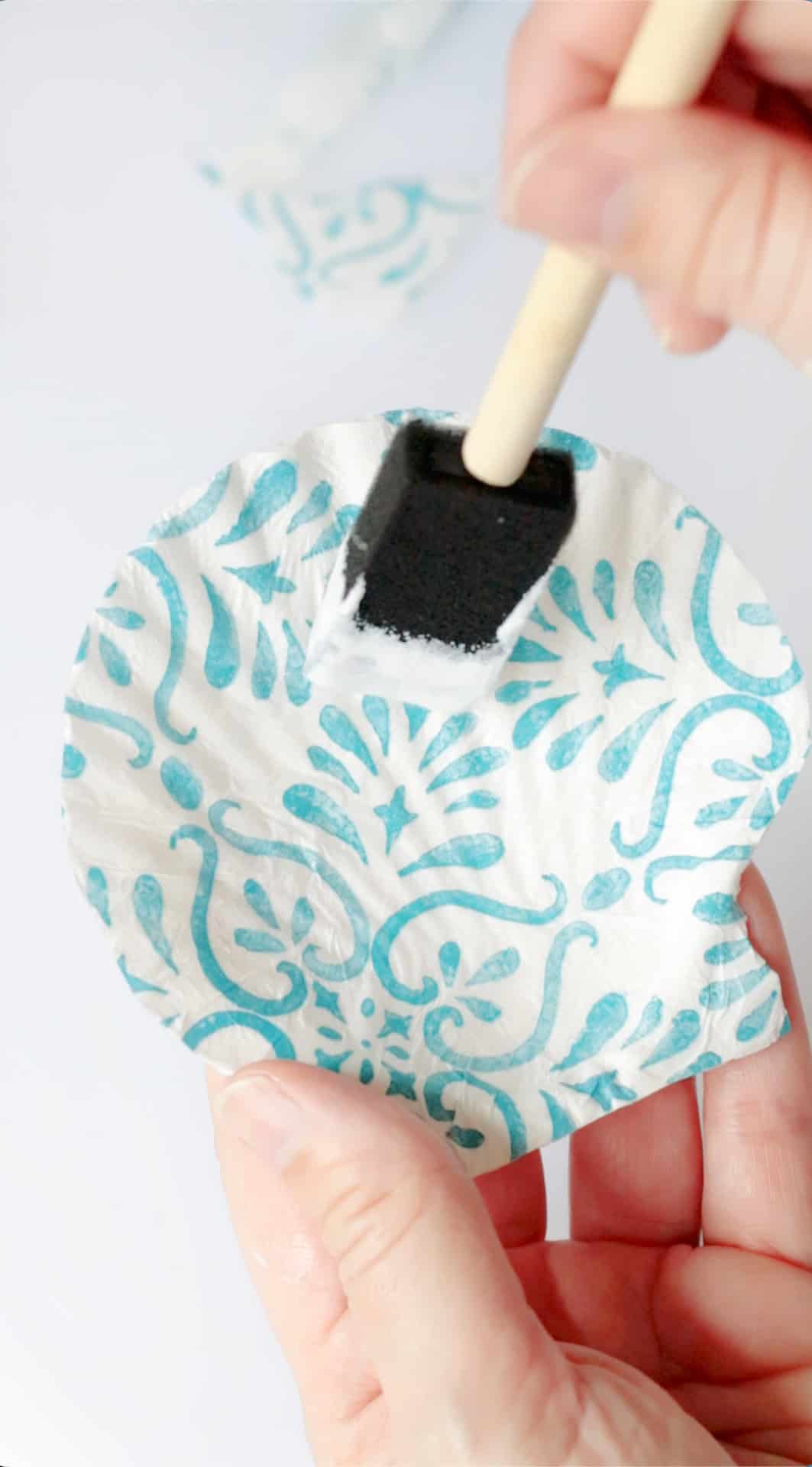 Sponge brush painting Mod Podge over napkin on shell.