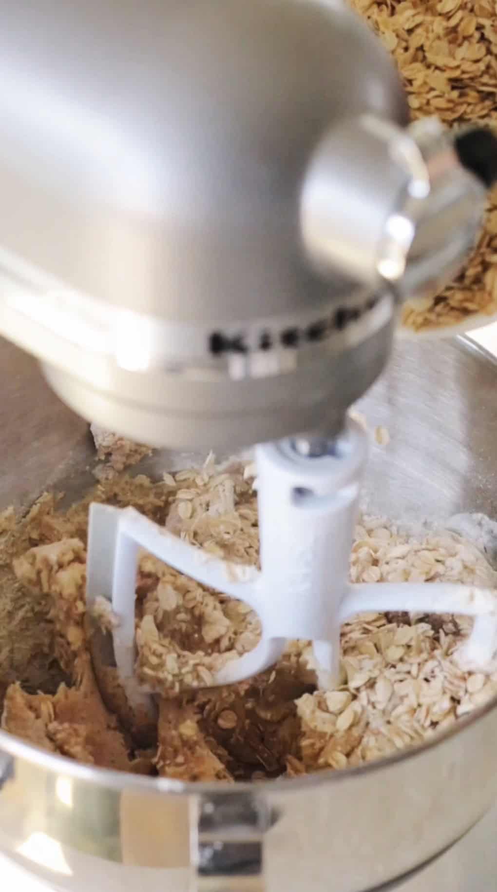 Stand mixer with oats added to cookie dough mixture.