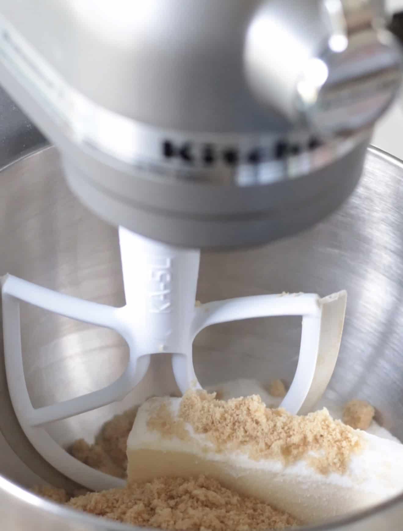 Stand mixer with butter and sugar in bowl.