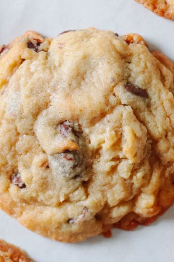 Chocolate chip cookie on parchment paper.