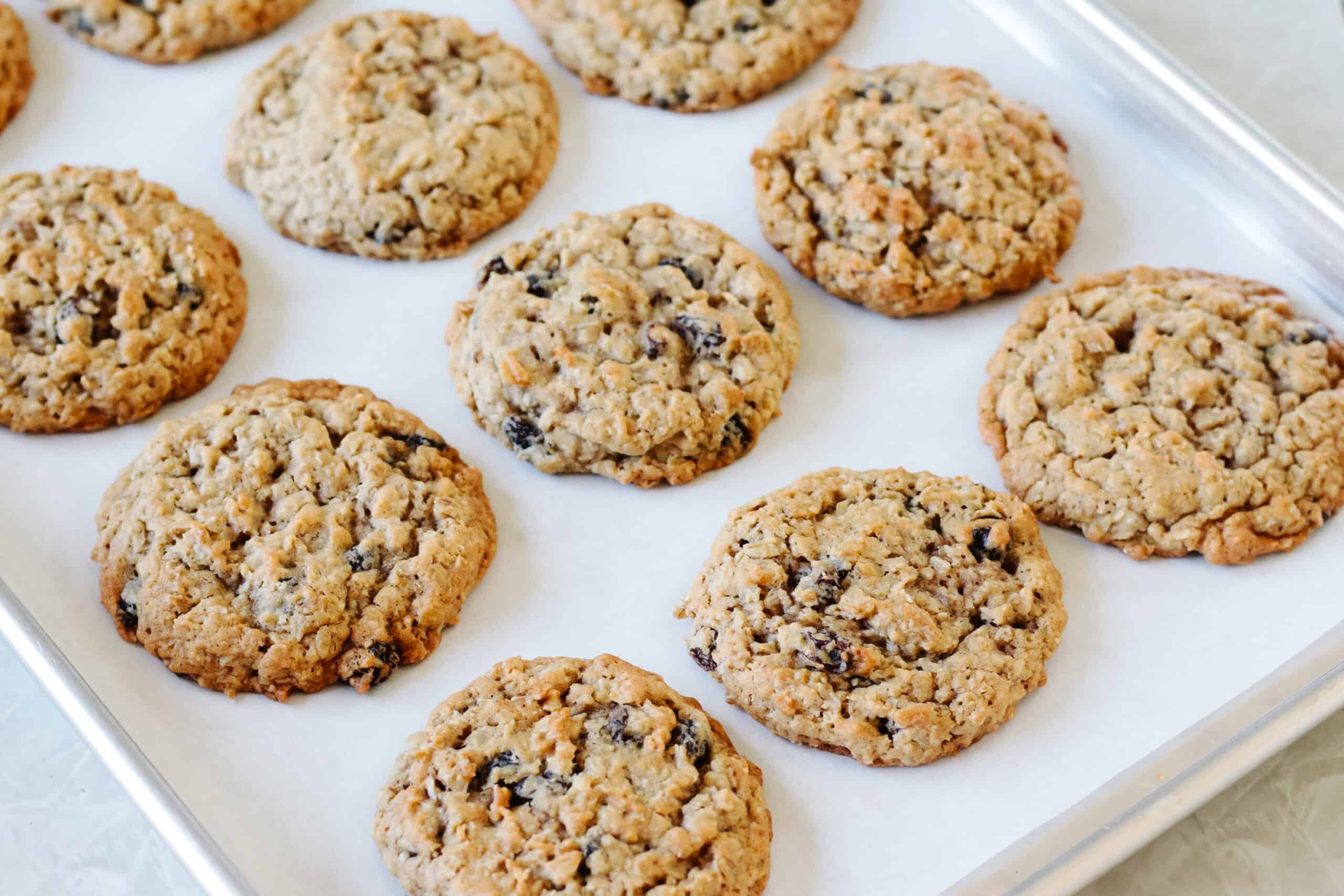 Oatmeal raisin cookies on baking sheet with parchment paper.