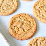 Peanut butter cookies on parchment paper lined baking sheet.