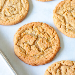 Peanut butter cookies on parchment paper lined baking sheet.