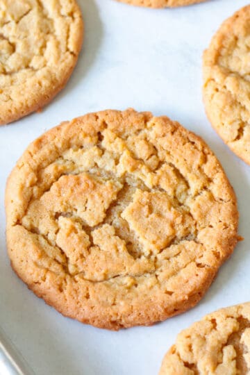 Peanut butter cookies on parchment paper lined baking sheet.
