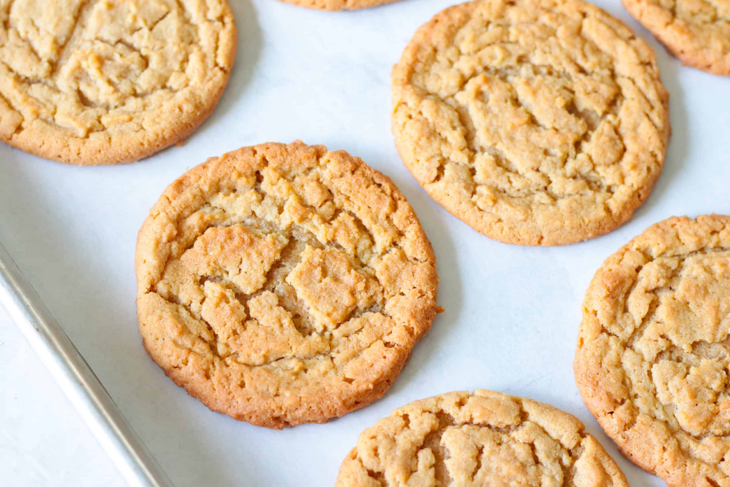Peanut butter cookies on parchment paper lined baking sheet.