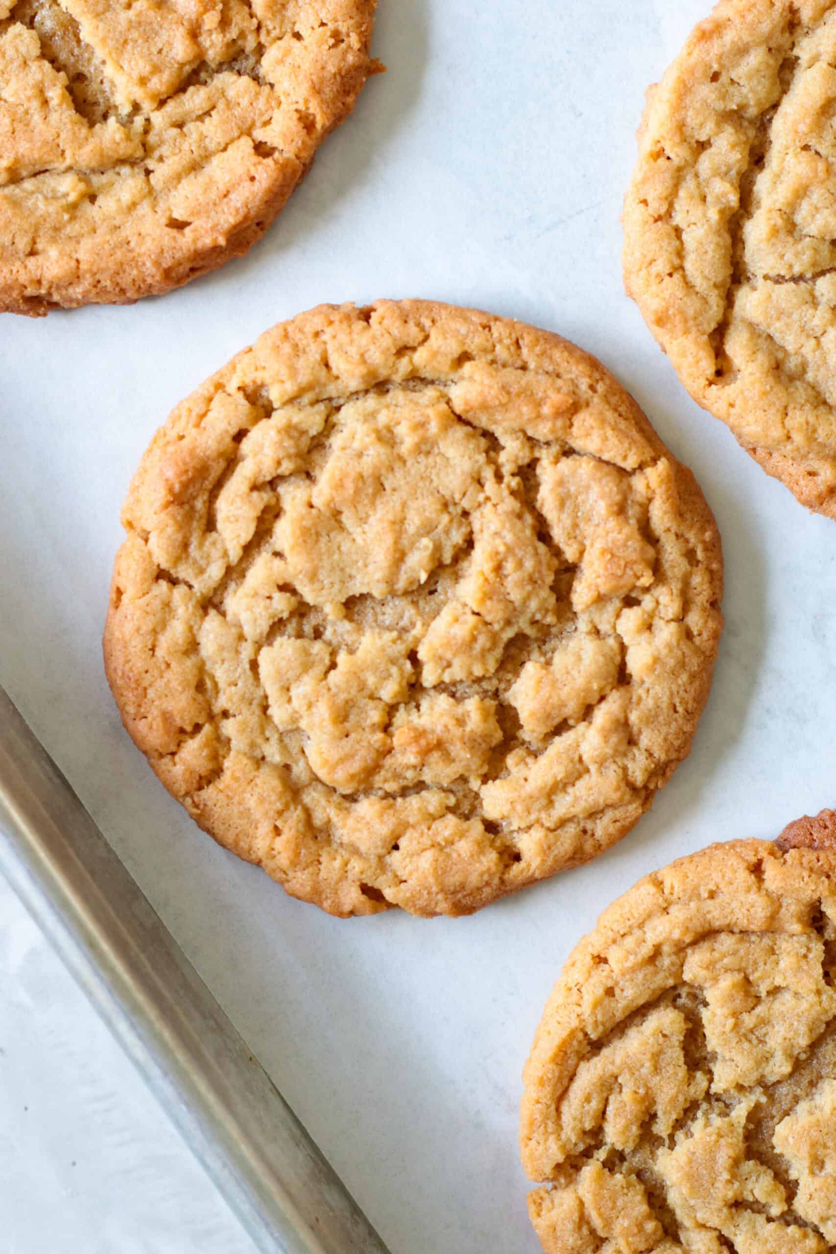 Peanut butter cookies on parchment paper lined baking sheet.