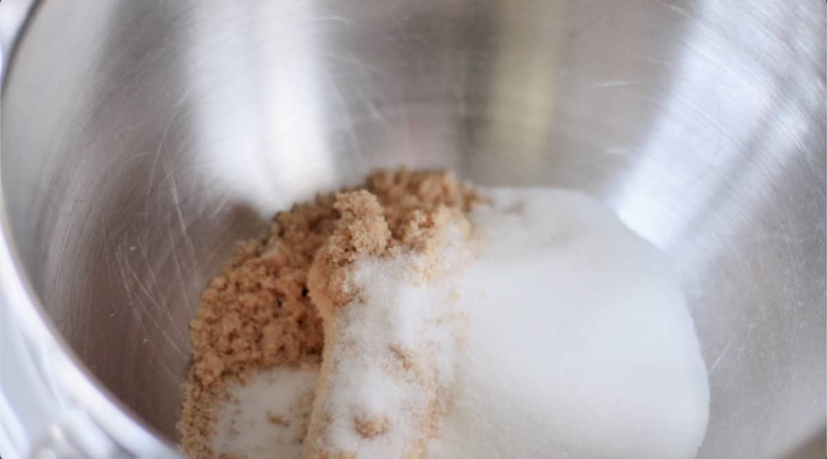 Metal stand mixer bowl with sugar and butter.