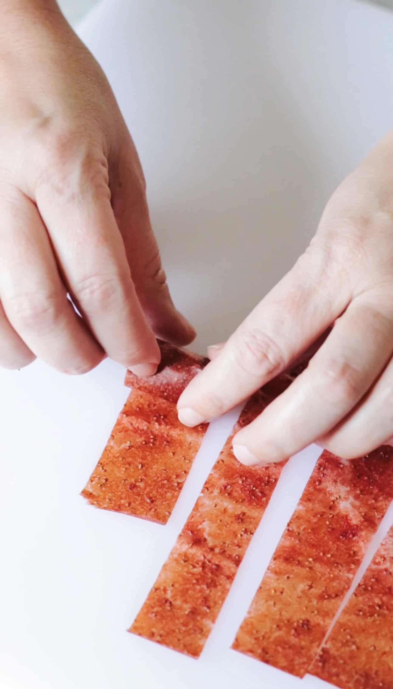 Hand rolling up fruit leather.