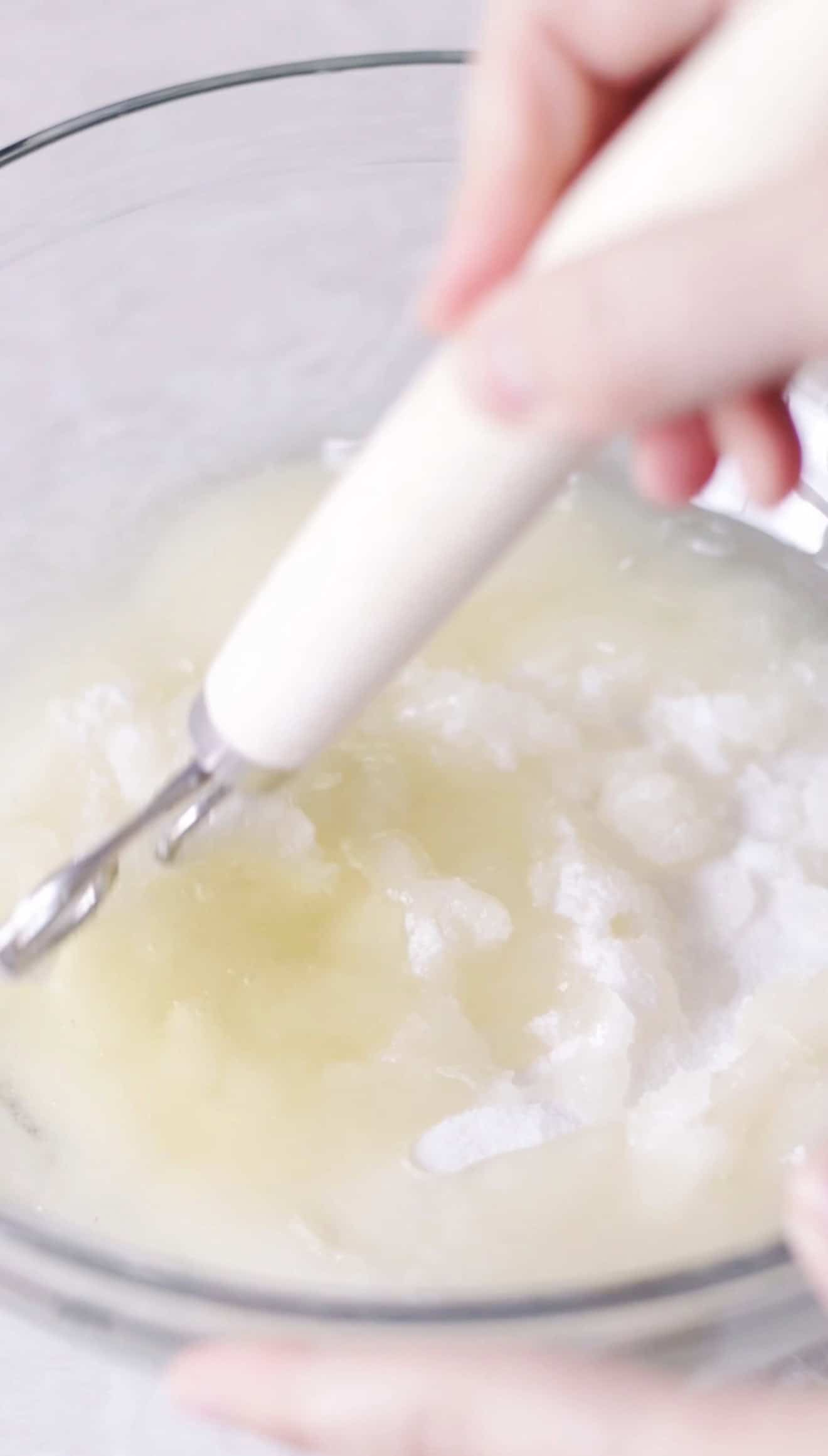 Glass mixing bowl of oil and granulated sugar.
