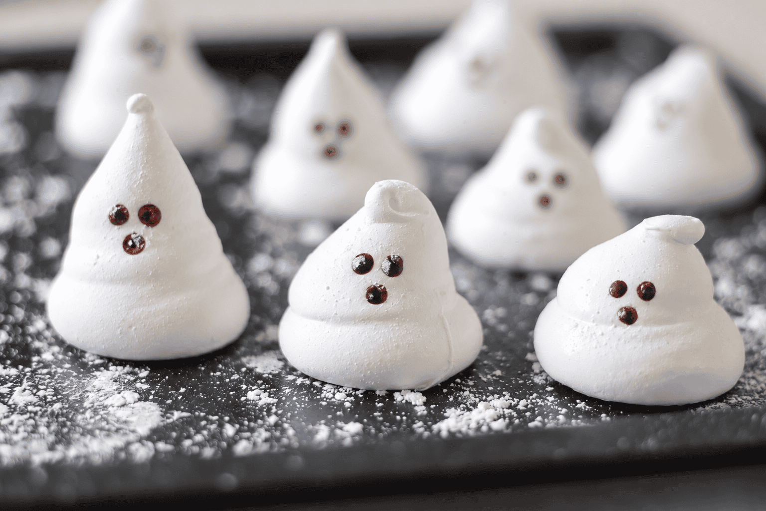 Ghost marshmallows on black platter.