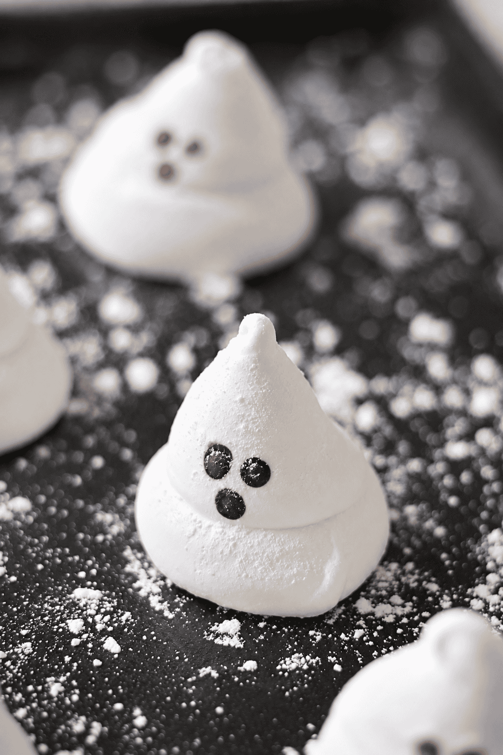 Ghost marshmallows on black platter.