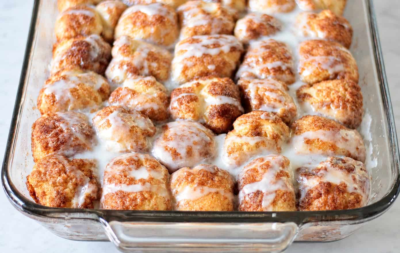 Cinnamon roll bites in glass baking dish.