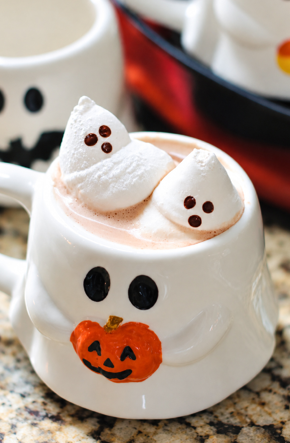 Two ghost marshmallows in mug of hot cocoa.