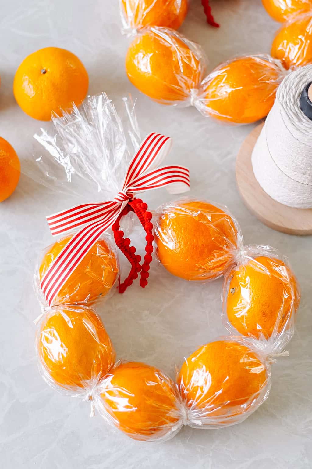 Clementine wreath next to spool of white twine.