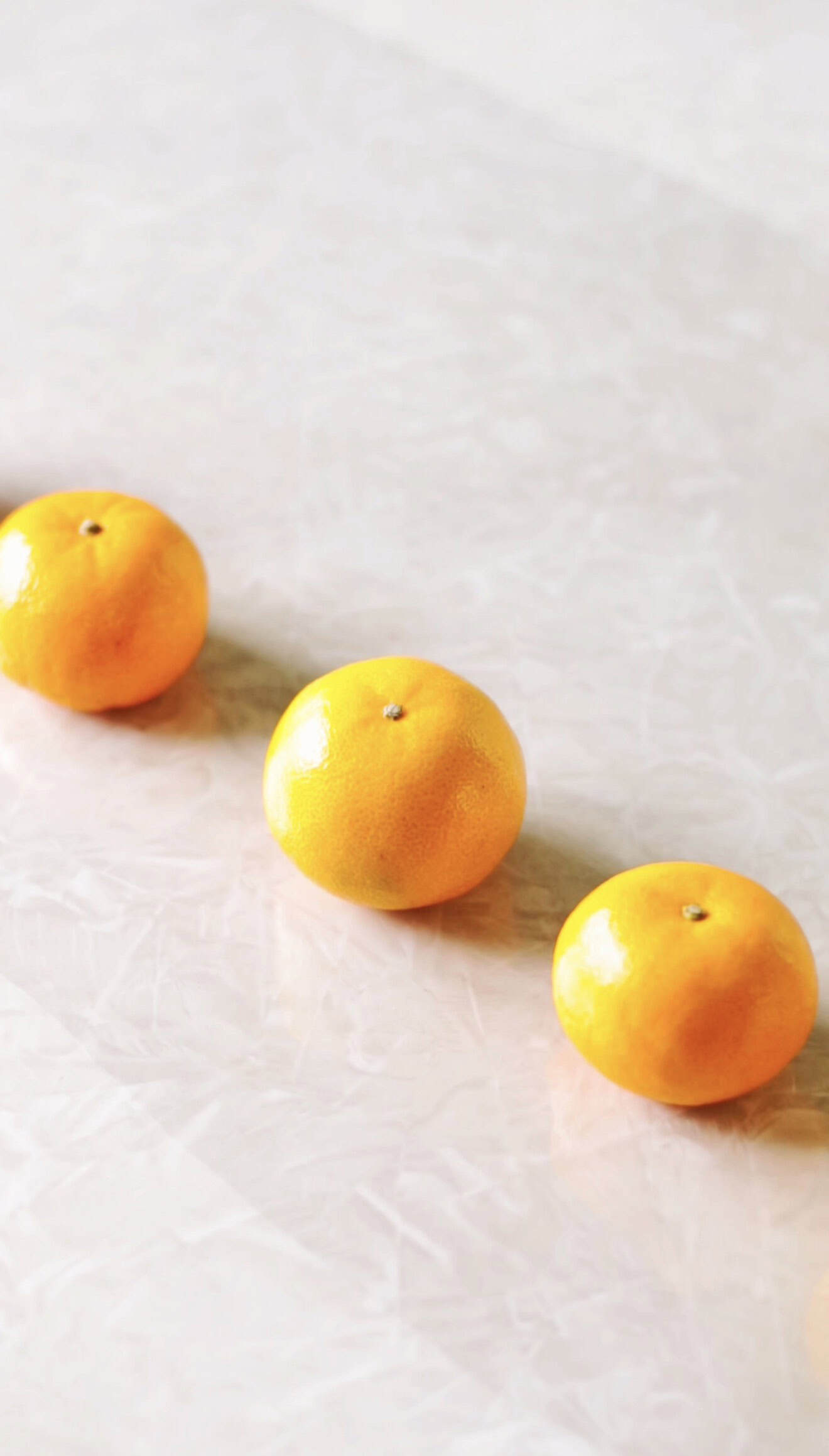 Clementines lined up on cellophane.