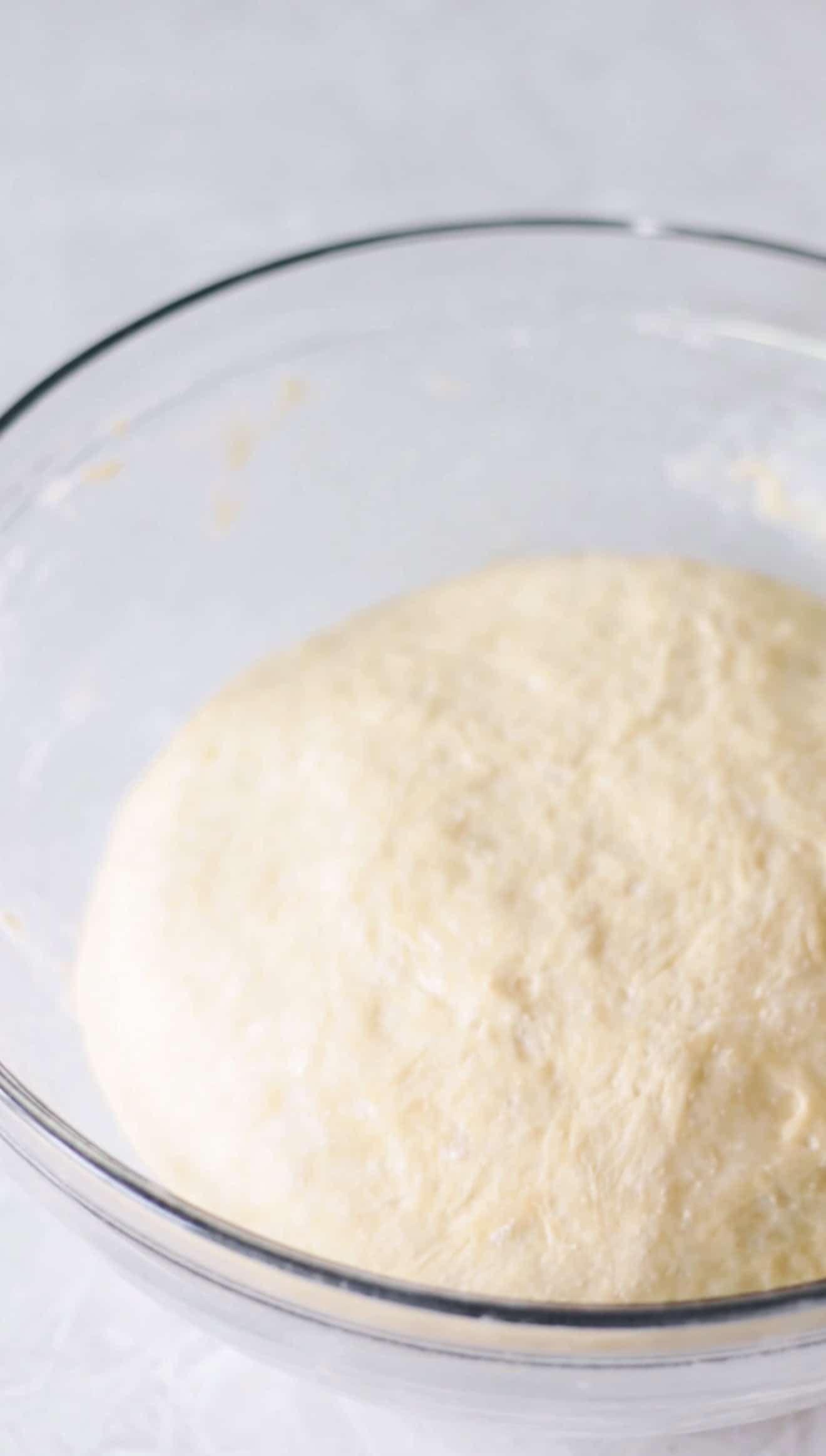 Glass mixing bowl of bread dough.