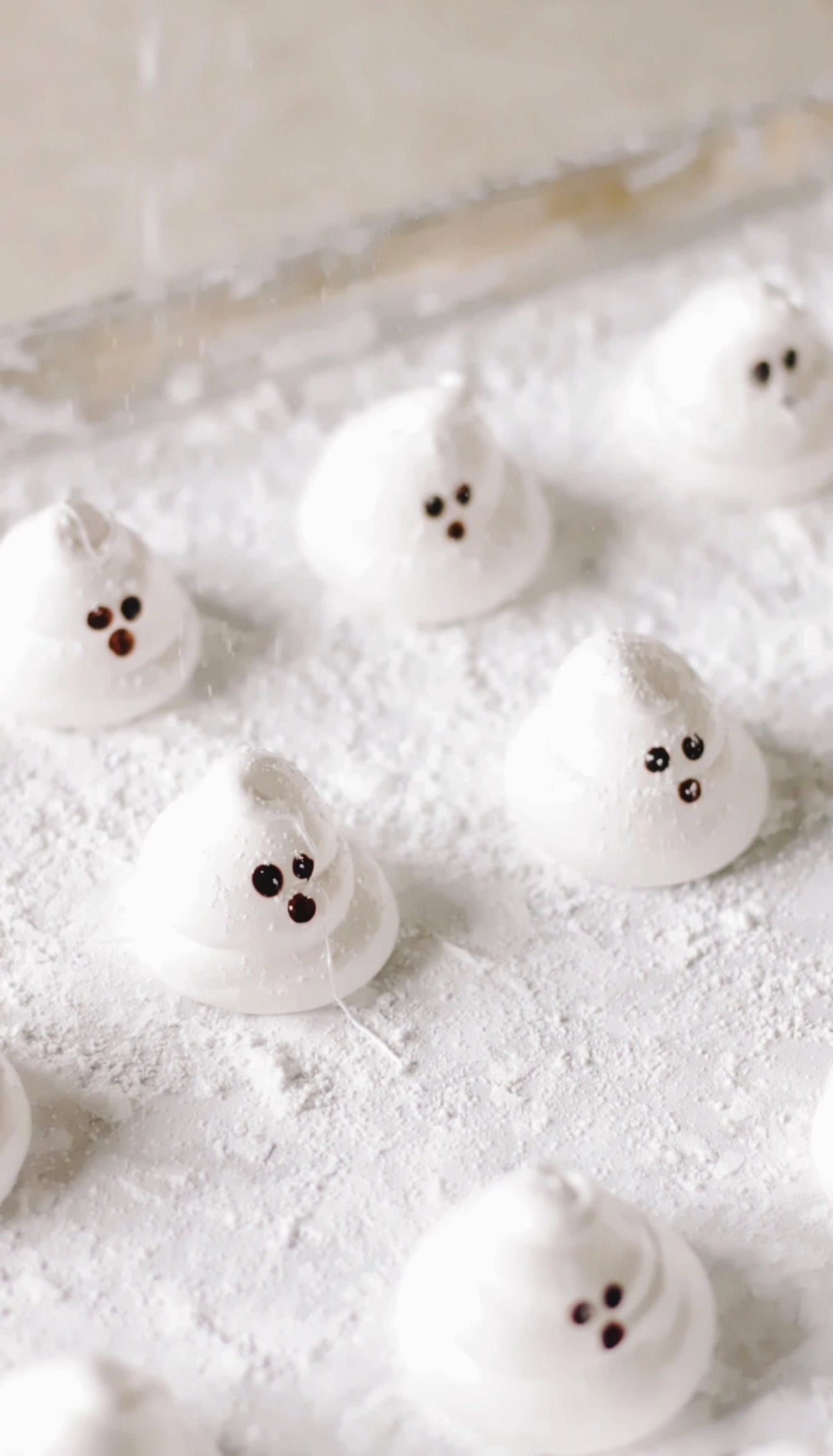 Ghost marshmallows on baking sheet.