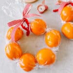 Clementine wreaths on table.