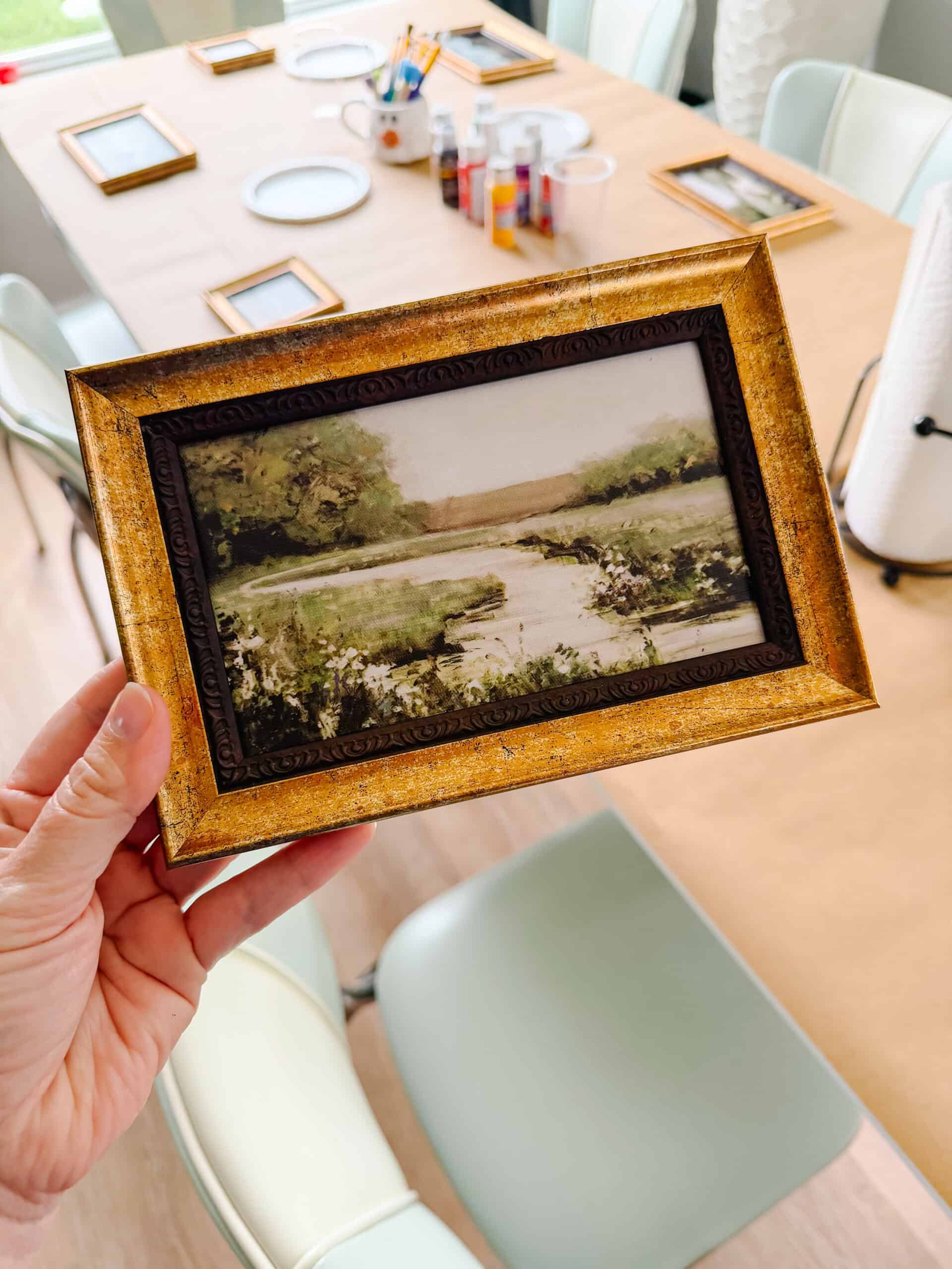 Hand holding framed artwork.