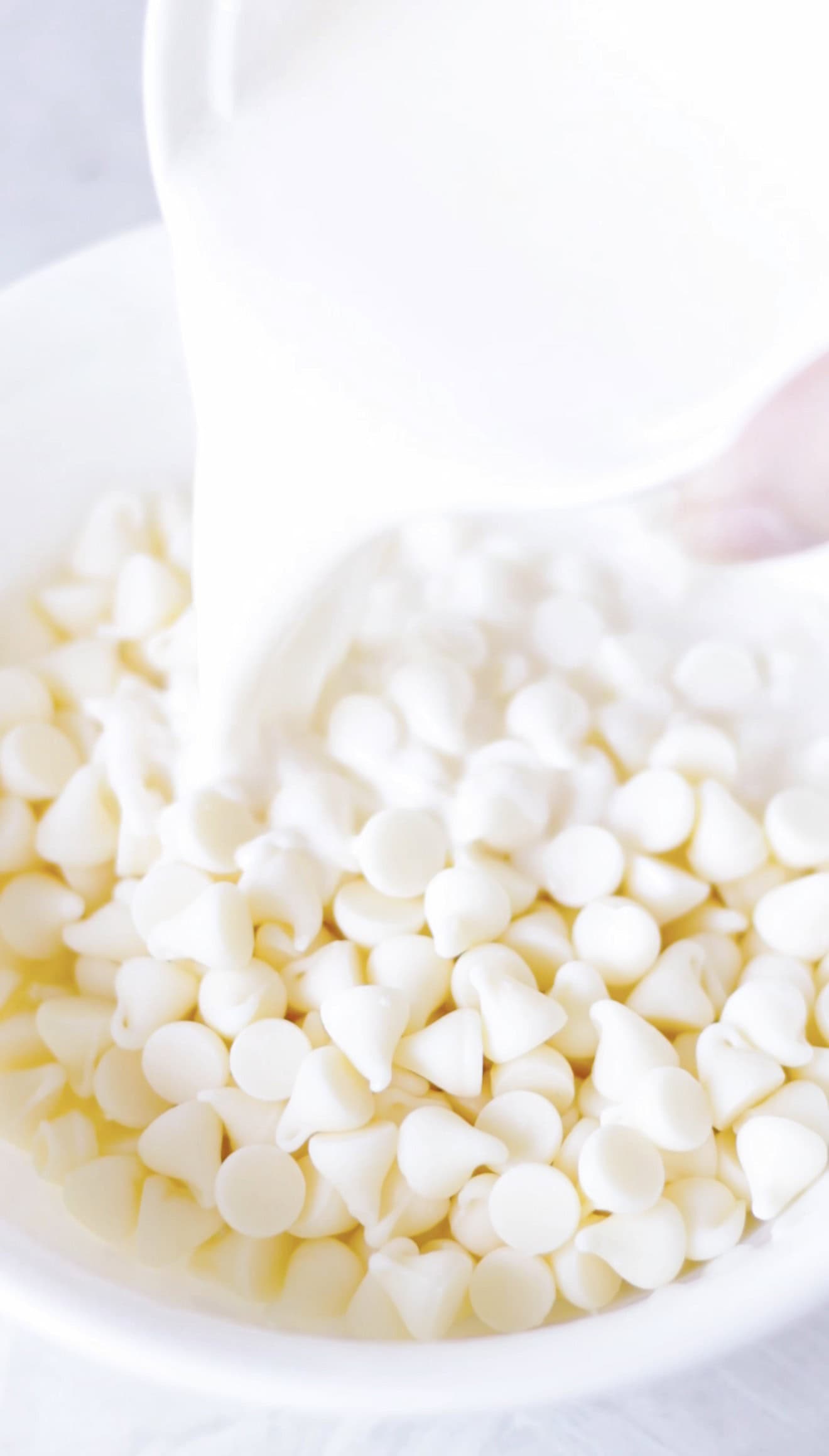 Bowl of white chocolate chips and cream.