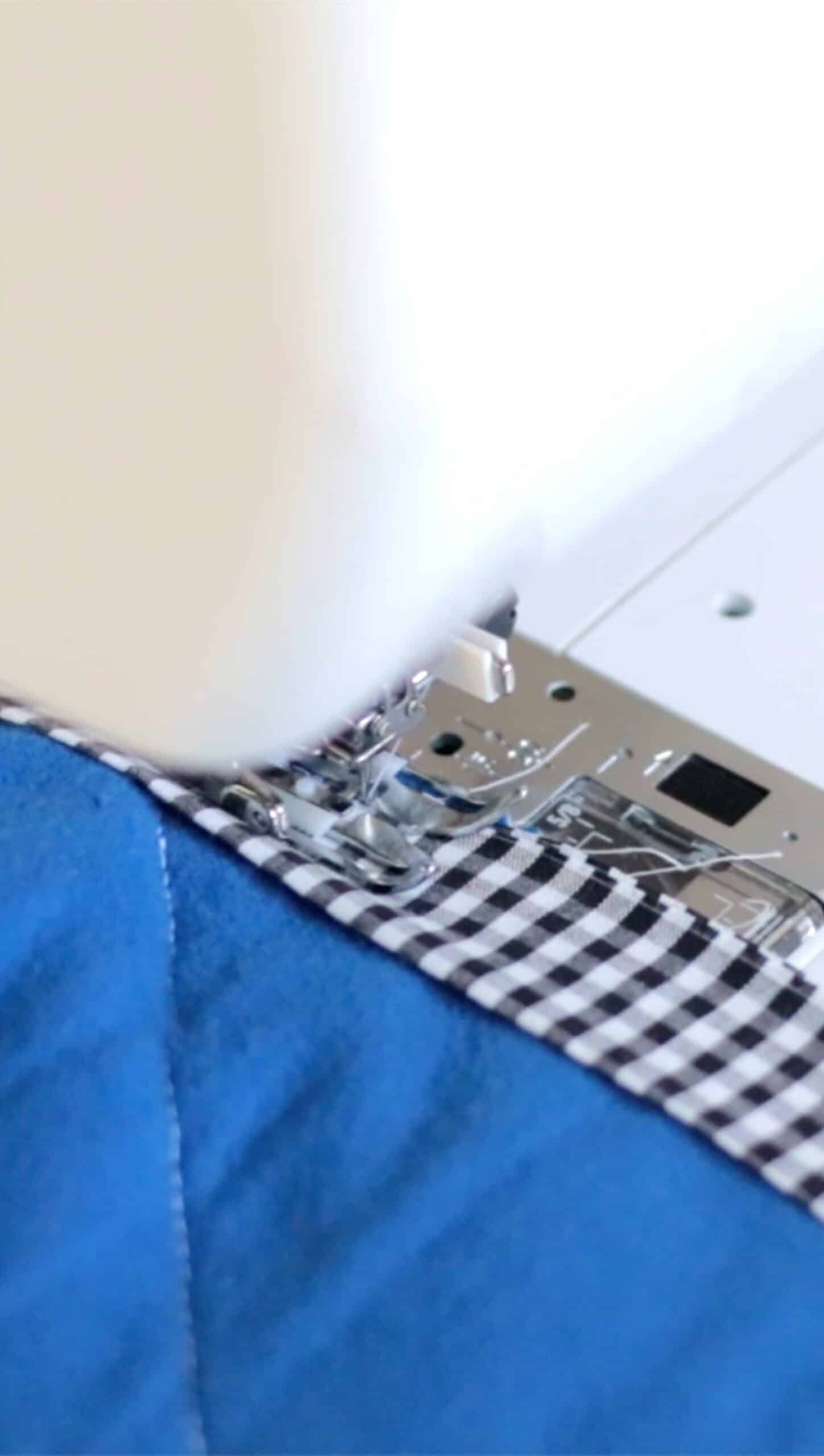 Sewing machine sewing binding to quilt.